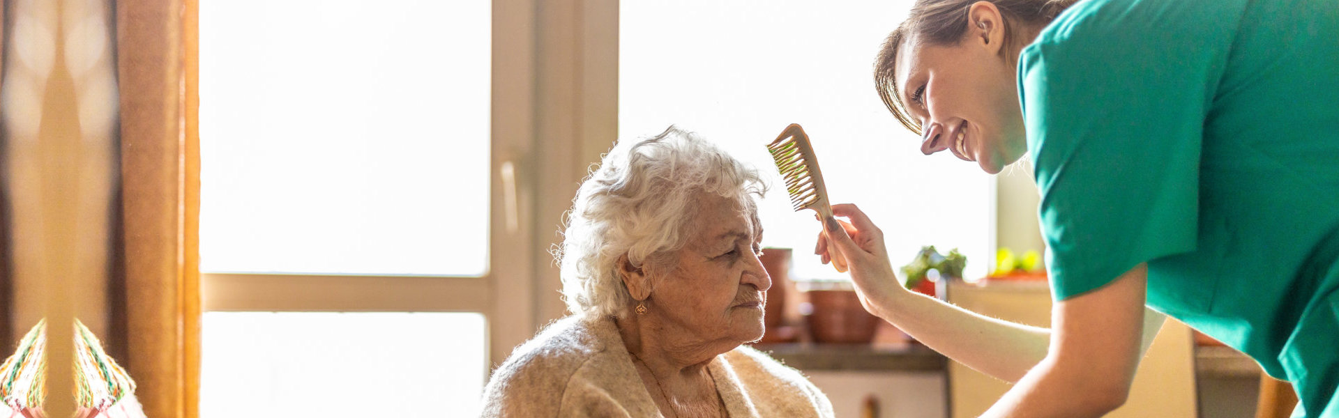 nurse combing the hair of senior woman
